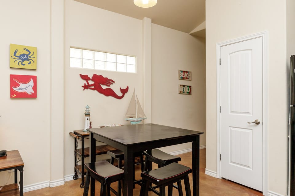 Gather around your charming dining table, surrounded by playful beach art and nautical touches that make every meal feel like a coastal escape.