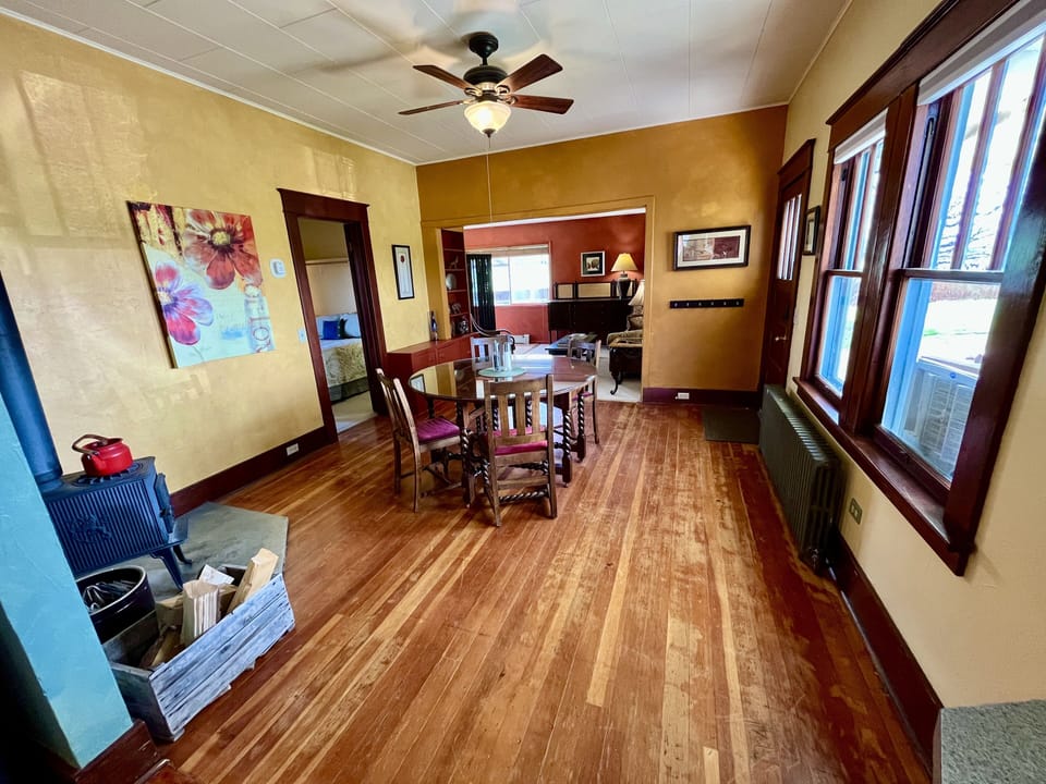 Dining room with lots of natural light and a wood stove.