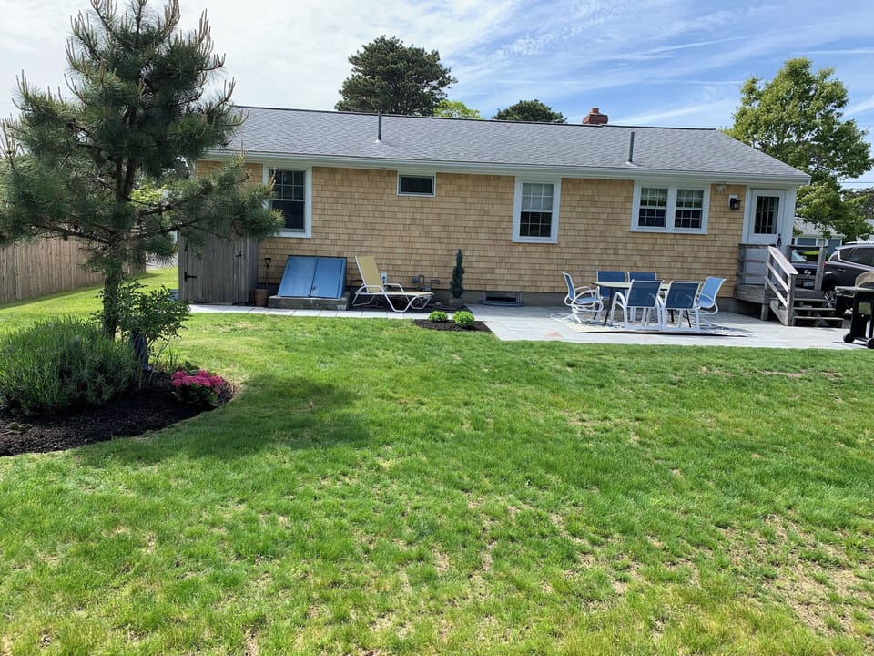 Blue stone patio with grill and seating.  Expansive backyard for activities.