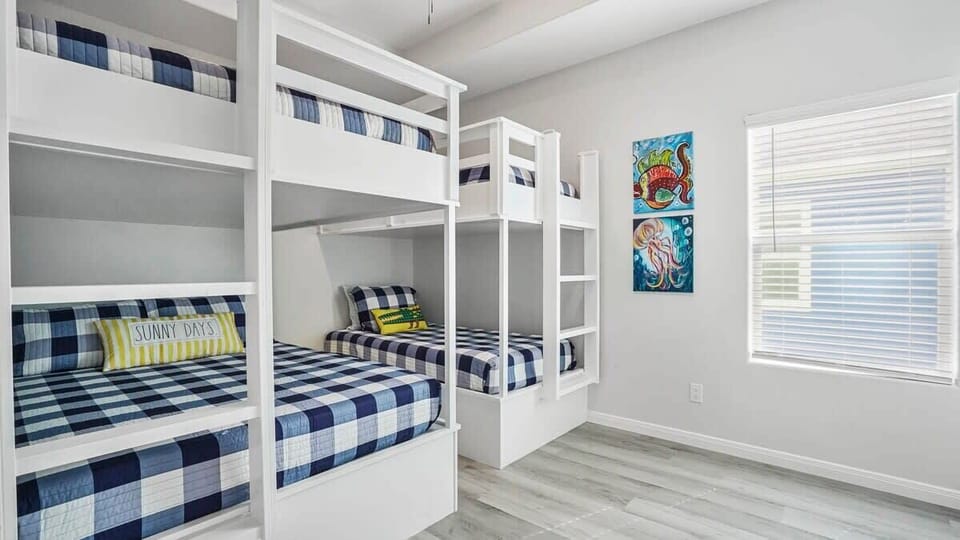 Bunk room with custom bunks, 32 inch smart TV, docking station for electronic devices, tower fan, & 2 luggage racks. 