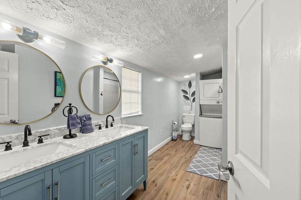 Your own sleek, spacious en suite with double sinks and stylish blue cabinets, perfect for a modern touch of comfort!