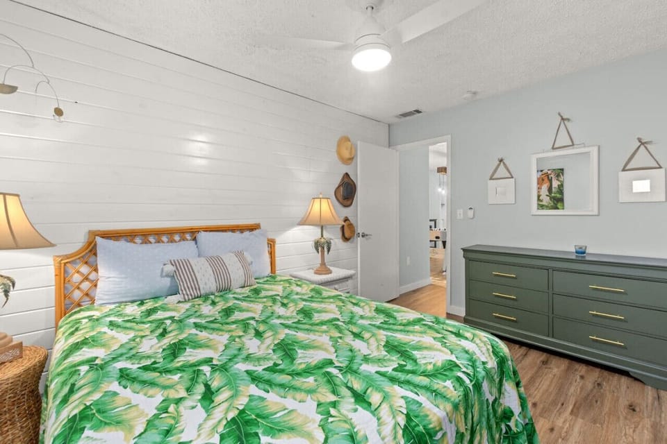 Queen bedroom featuring vibrant tropical décor, offering a comfortable and inviting space that sleeps 2.