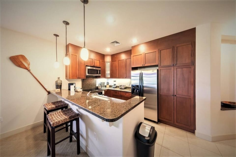 With granite counters, African Mahogany cabinets, and high-end Whirlpool Gold appliances this kitchen is stocked with coffee maker, toaster, blender, pots, pans, dinnerware and silverware. 