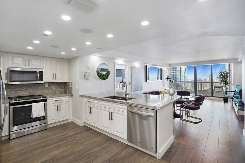 Fully equipped kitchen with separate laundry room, dining area, living room, balcony access