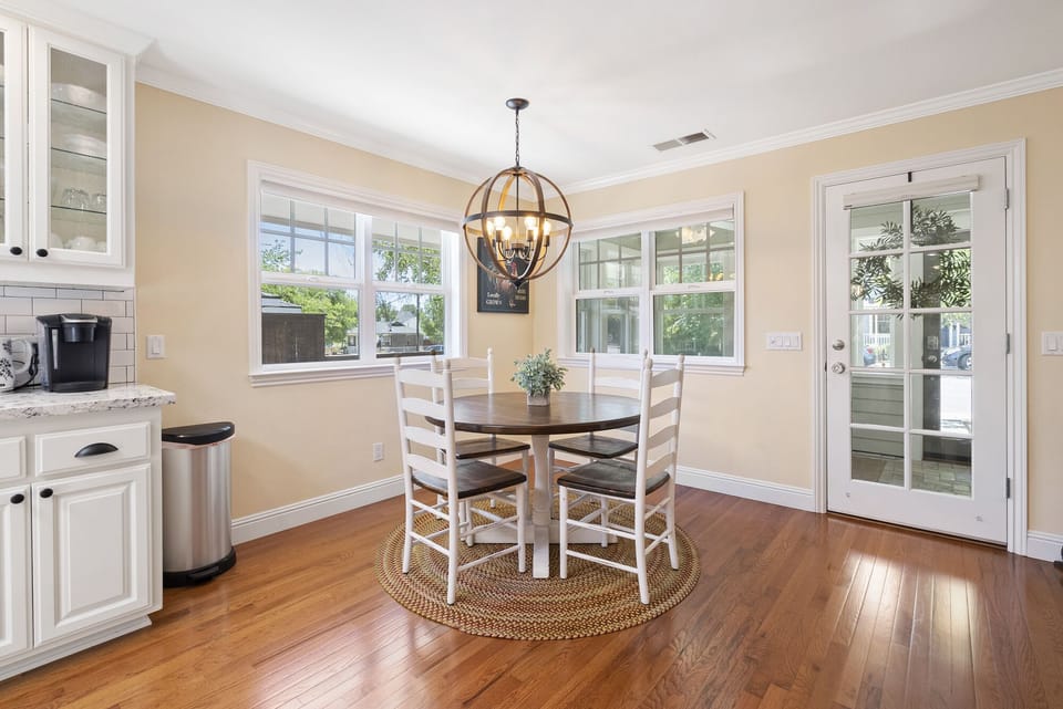 A round table beneath a sculptural pendant light brightens the nook