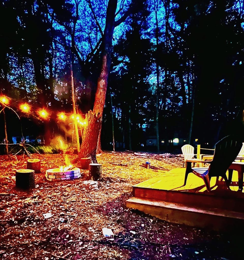 Unwind under the stars with a private firepit, string lights, and peaceful wooded surroundings — perfect for s’mores and late-night conversations