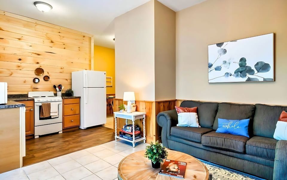 Cozy vibes and rustic charm in our open floor plan living area and kitchen. Definitely, loving the wood paneling that adds a touch of warmth to the space!