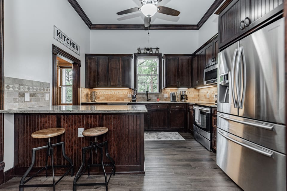 Kitchen with plenty of dishes, large fridge, and island, and pantry.