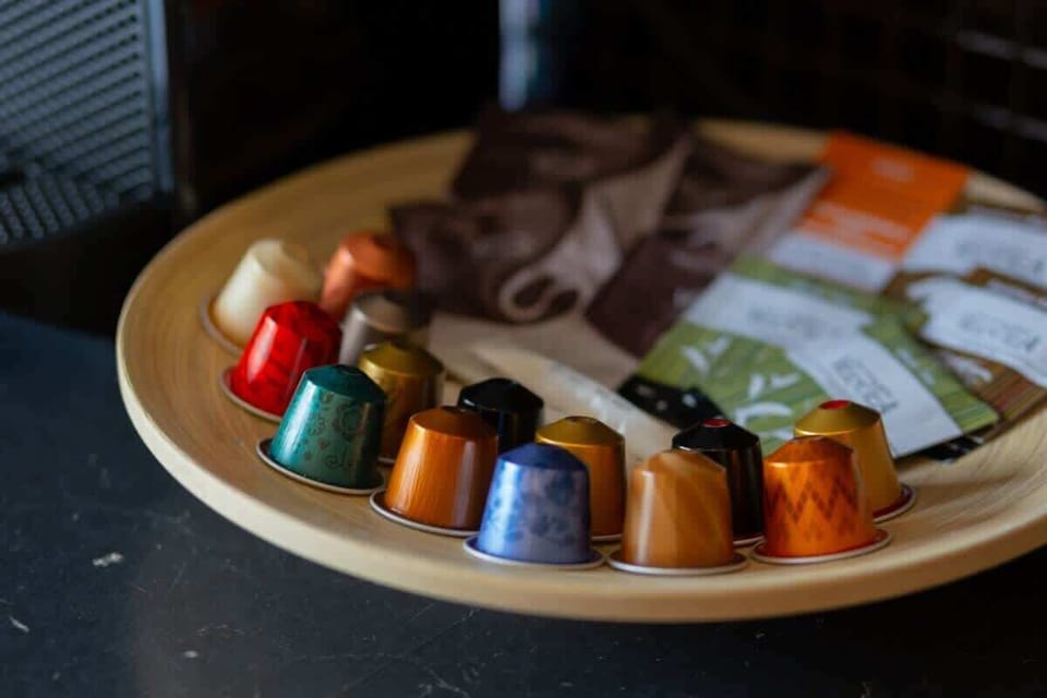 A close-up of a coffee tray with colorful coffee capsules and a mug, creating a cozy and inviting detail.