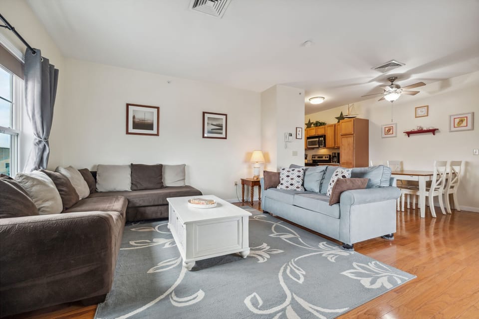 Living room with ocean views featuring both a sectional and pull-out couch, and access to the private balcony!
