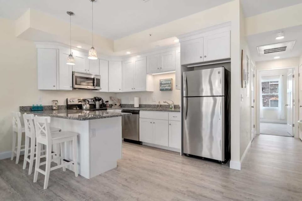 Open living room & kitchen with sleeper sofa, mounted smart TV, strong WiFi and fully-equipped kitchen