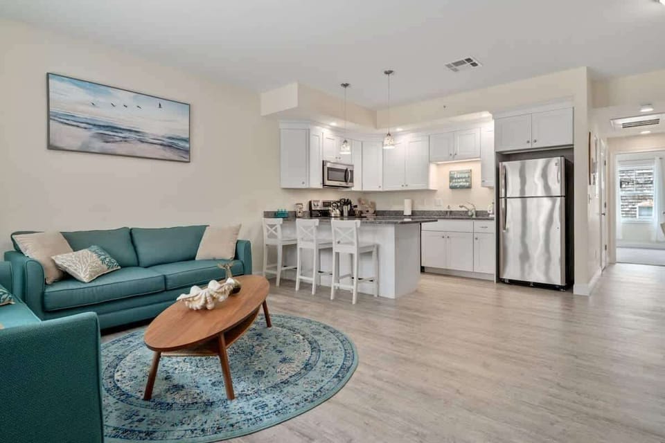 Open living room & kitchen with sleeper sofa, mounted smart TV, strong WiFi and fully-equipped kitchen