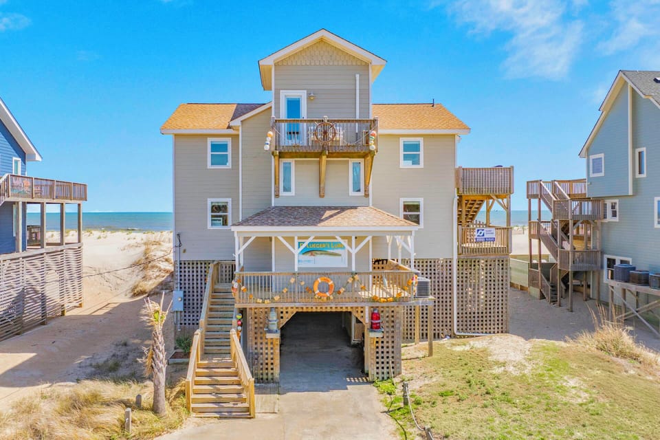 Charming beachfront property with elevated decks and direct beach access, nestled among coastal homes with ocean views.