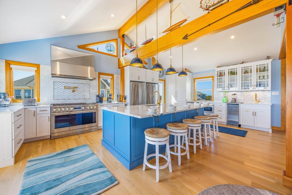 Your gourmet kitchen awaits with a stunning blue island, professional appliances, and cozy breakfast bar seating for memorable meals together.