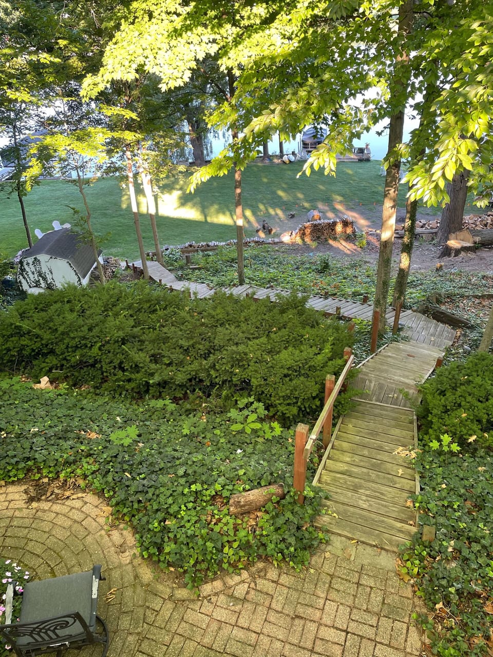 A meandering path of very shallow stairs down a wooded hill to the lakeside.  