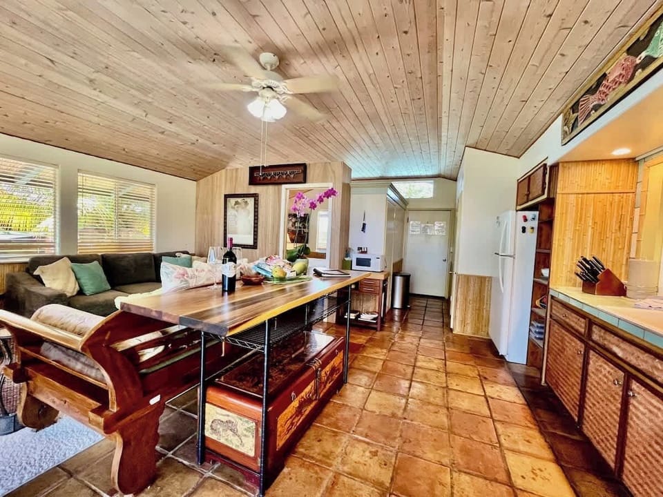 Kitchen Living room with tropical decor and adjacent kitchen area.