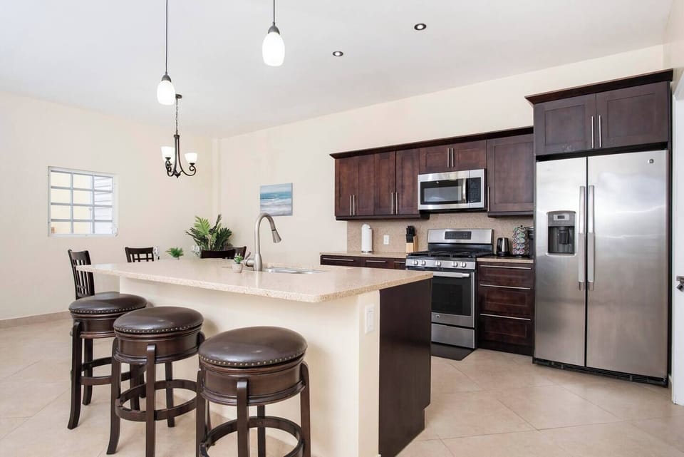 Galley style kitchen w/ recessed lighting.  Pendant  lights adorn the island where you can sit and chat while gourmet meals are being prepared.