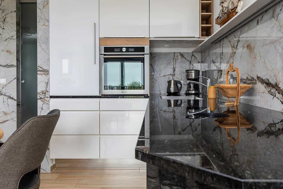 Kitchen cabinets with a marble backsplash and metallic accents, adding a luxurious touch to the space.