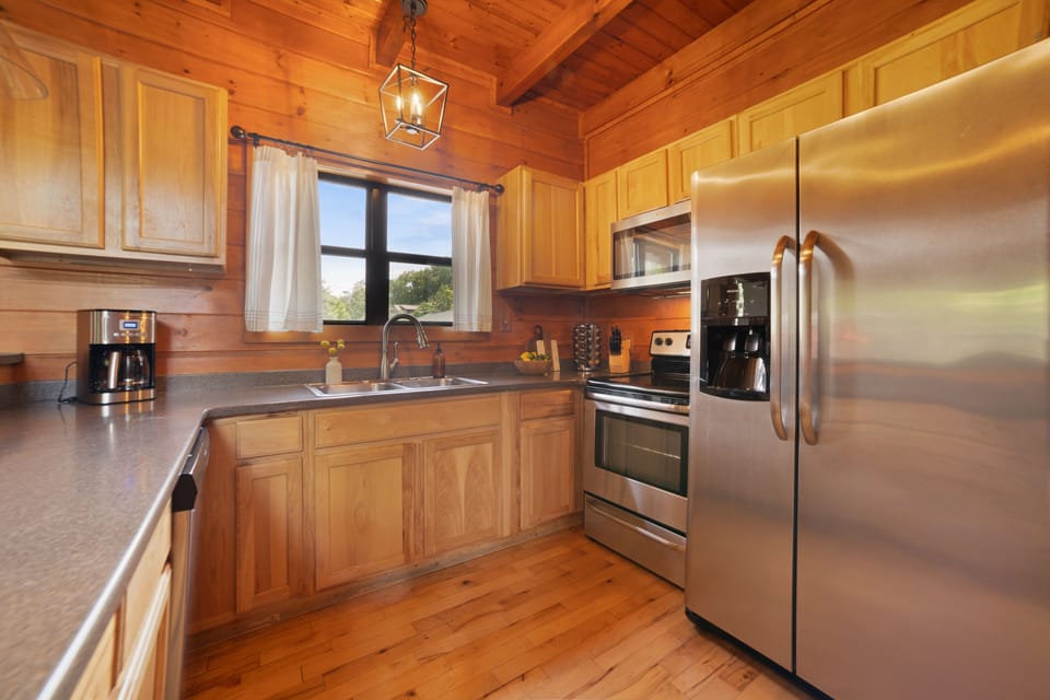 Spacious kitchen with stainless steel appliances and a large fridge and freezer.