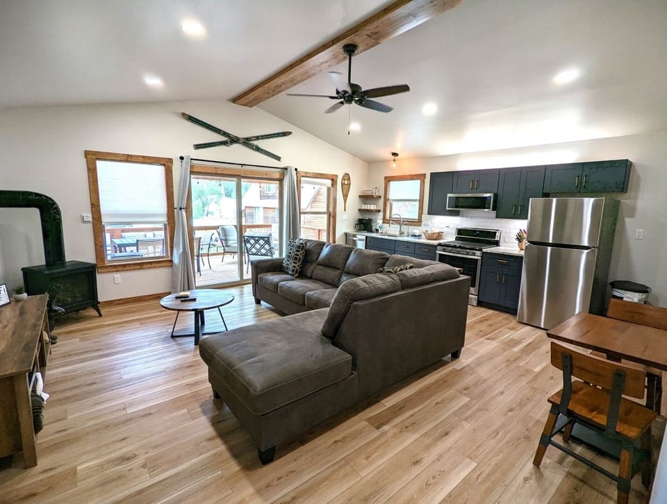 Stretch out in your inviting open-concept living space, where rustic beams meet modern comfort. Cozy up by the wood stove or step through glass doors to your private deck with sweeping views.