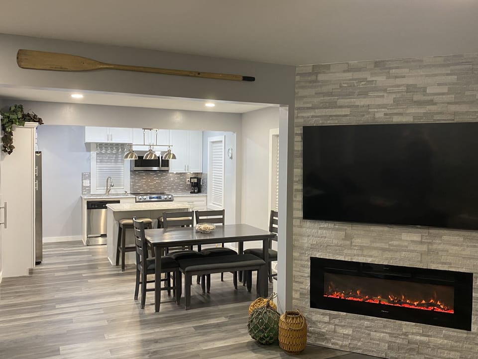 Great room with Samsung smart TV, electric fireplace, dining and kitchen. 