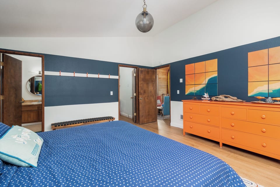 Relax in your vibrant bedroom with bold blue walls and cheerful orange furniture creating a playful, energizing atmosphere for restful nights.