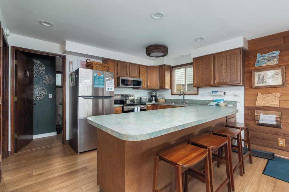 Your spacious kitchen welcomes you with warm wood cabinetry, granite countertops, and a breakfast bar perfect for morning coffee or meal prep.