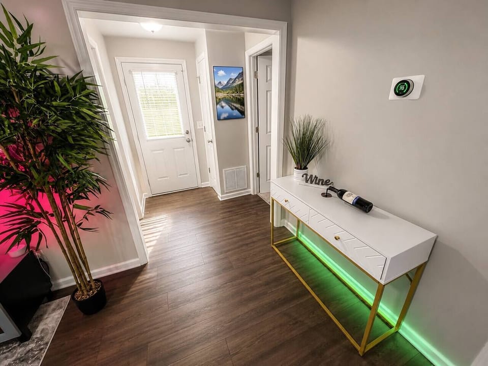 A bright, modern entry welcomes you with warm natural light, elegant décor, vibrant greenery, and subtle LED accents. The perfect first impression before relaxing in your stylish X7 Stays getaway.