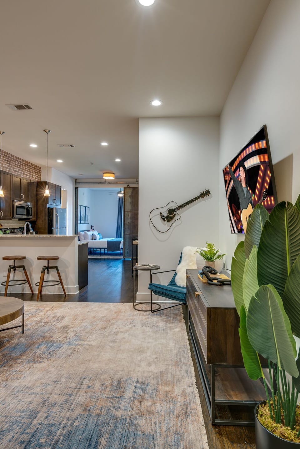 Open concept living area with designer furnishings and smart TV.