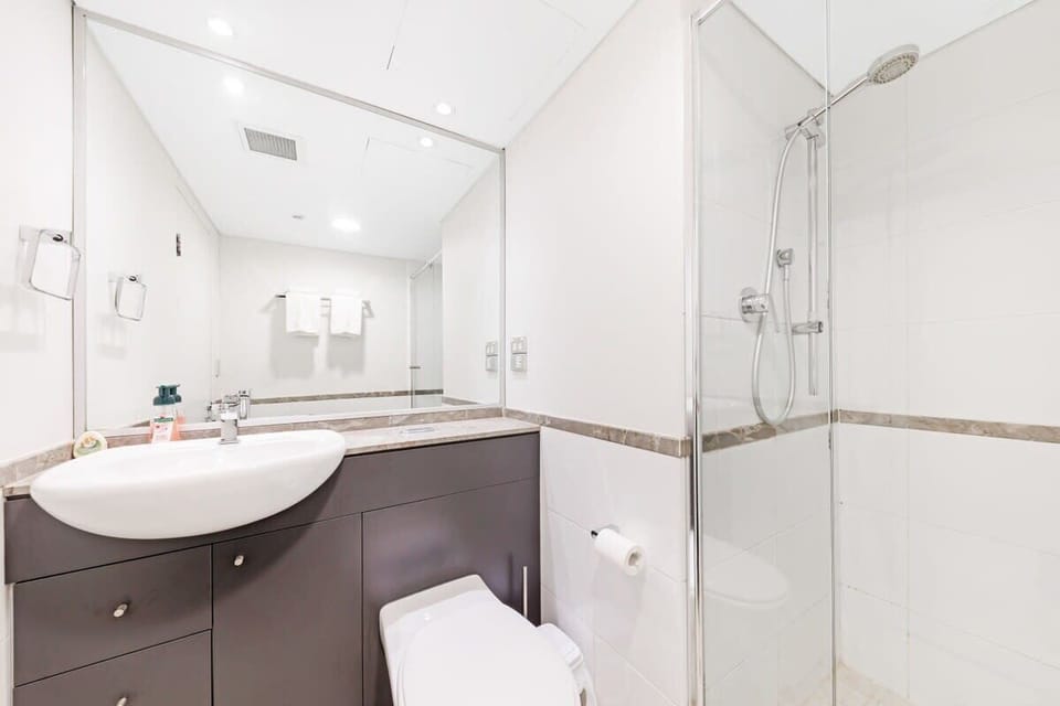 Second bathroom with vanity, shower/bathtub combination, and toilet.