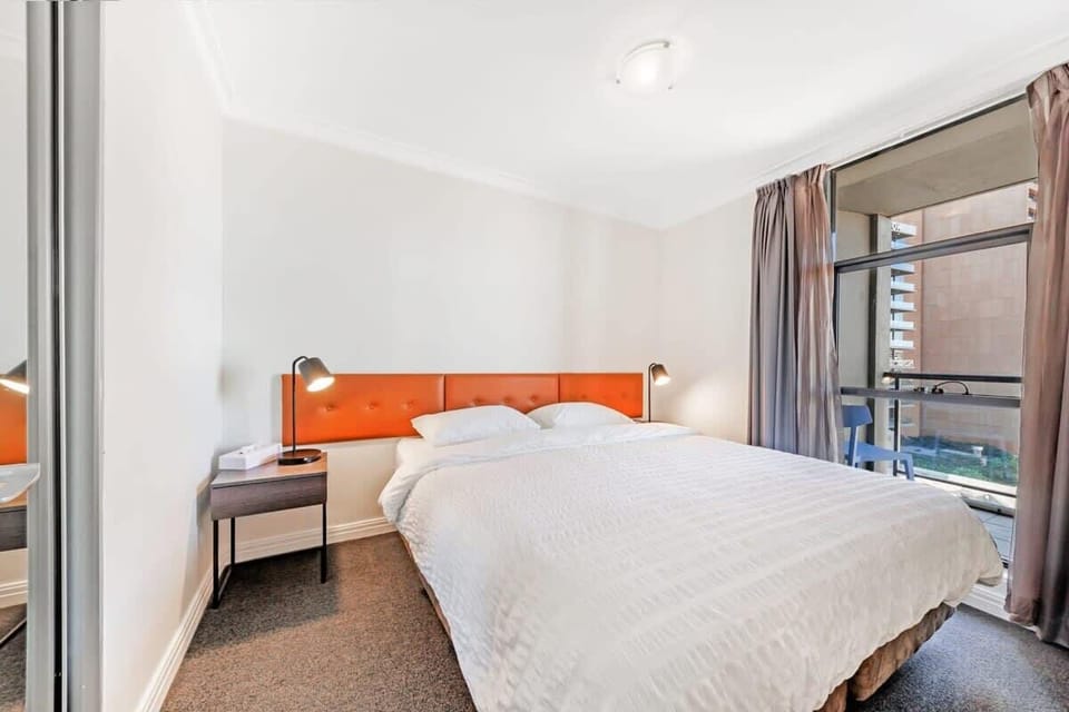 Additional bedroom featuring a king-size bed, bedside table, and balcony access.