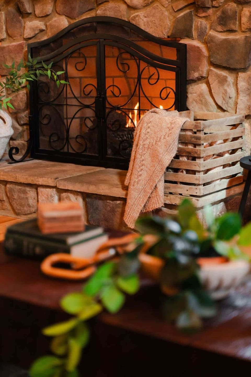 Living Room: Gather by the charming stone fireplace, surrounded by lush greenery and warm decor!