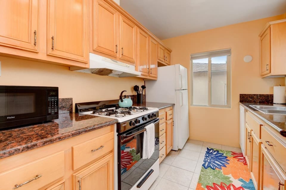 The kitchen includes a stove, refrigerator, microwave, toaster, and a Keurig coffee maker.