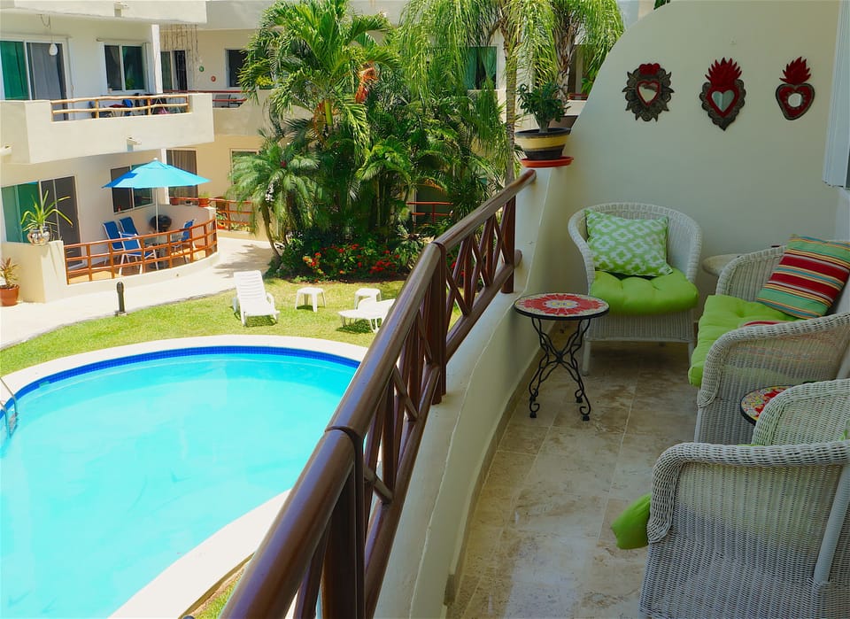 The balcony overlooking the swimming pool with comfy retro settee set