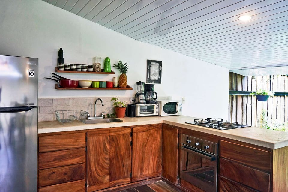 Modern wooden outside style kitchen viewing the pool and garden