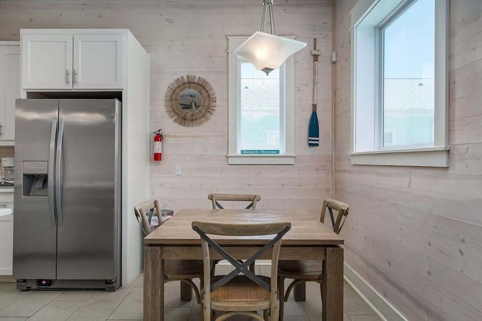 The dining room features a sleek and modern design with a warm and inviting atmosphere, making it the perfect space for entertaining guests or enjoying family meals