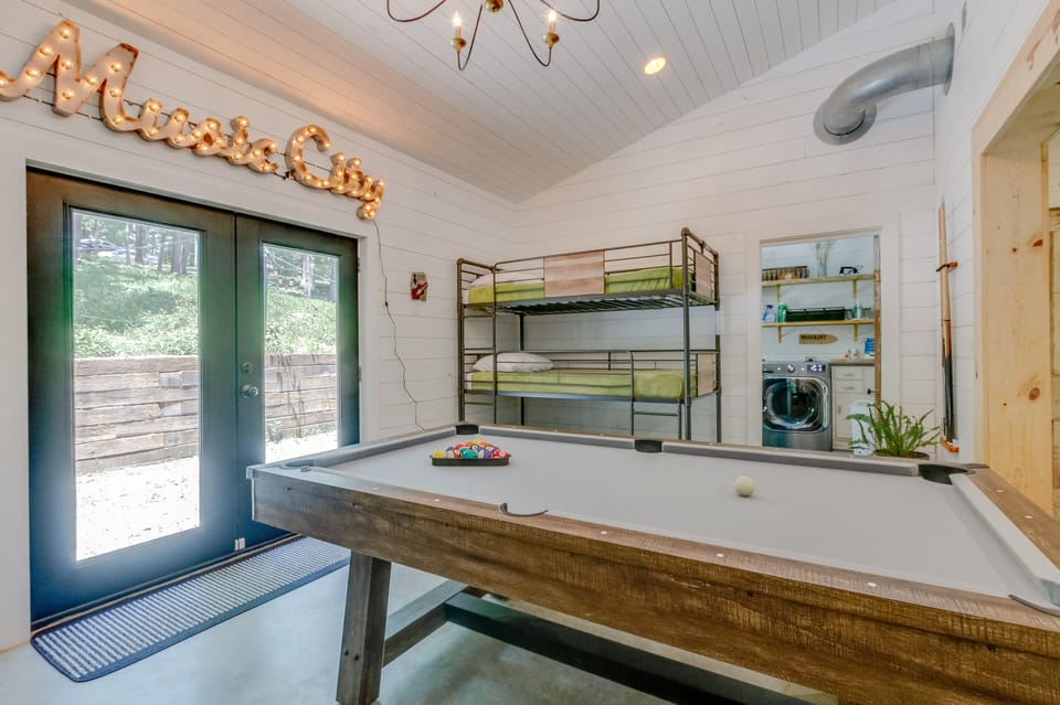 Game room complete with pool table, leather couch and 3 twin beds.