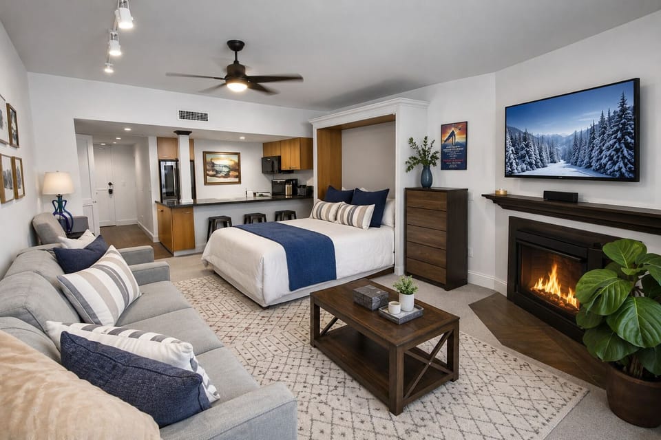 Unwind in your spacious studio where plush seating, a cozy fireplace, and modern amenities create the perfect mountain retreat after a day of adventure.