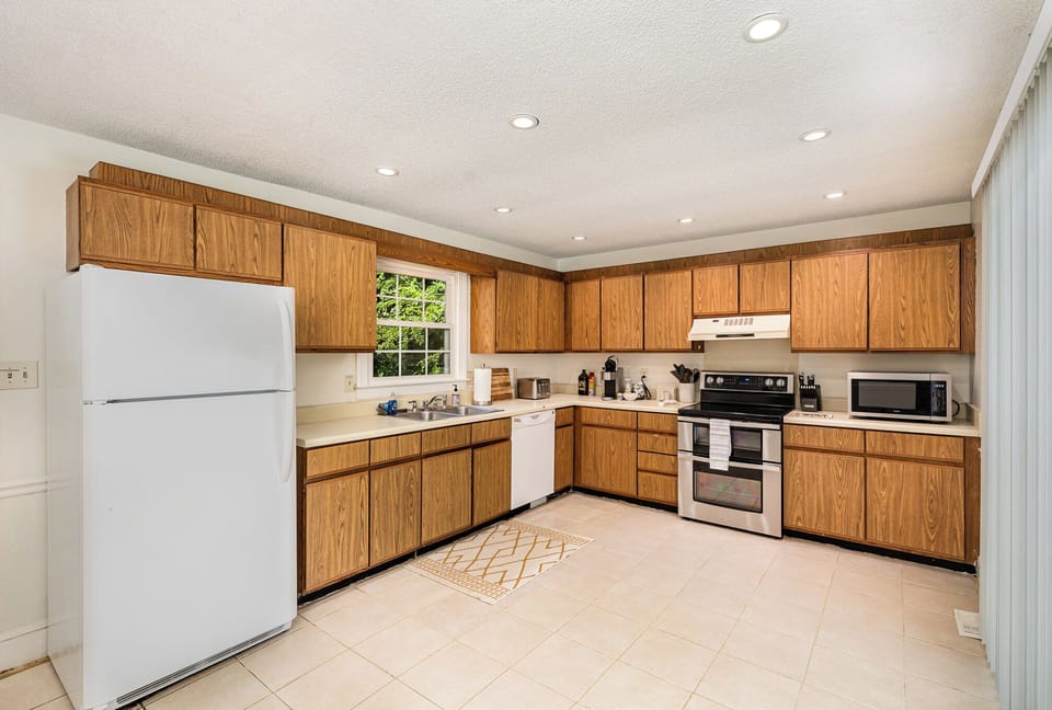 Spacious kitchen with labeled cabinets. Brita in fridge with cool water.