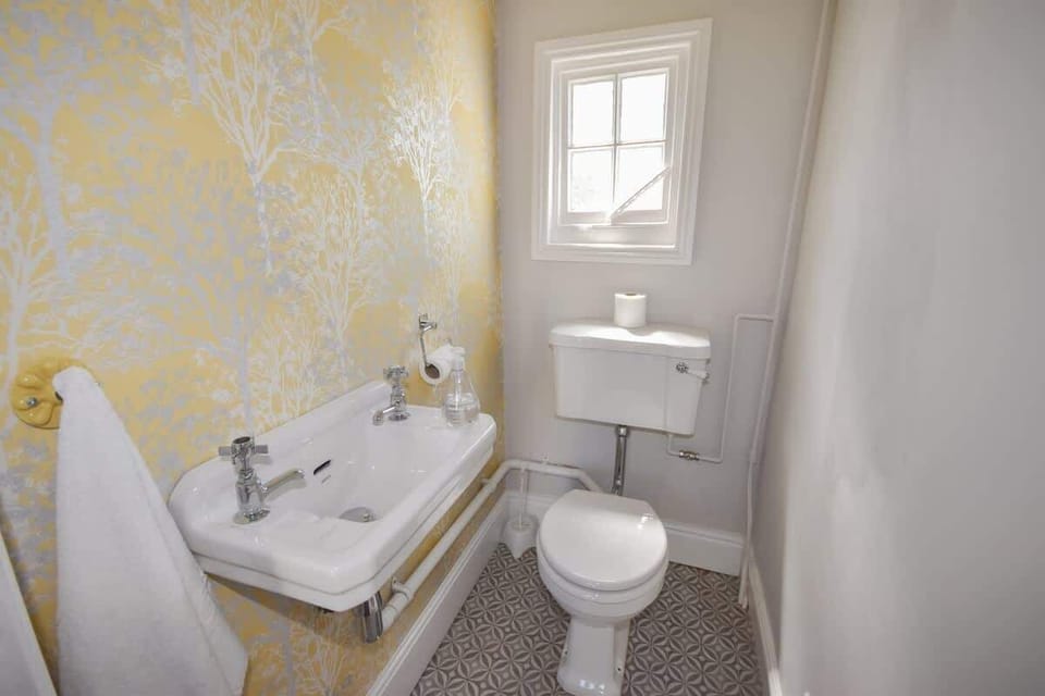 A convenient cloakroom located on the ground floor, featuring a modern toilet and washbasin for guest use.