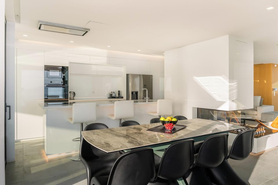 Kitchen is euro design sleek white furnished with full size appliances