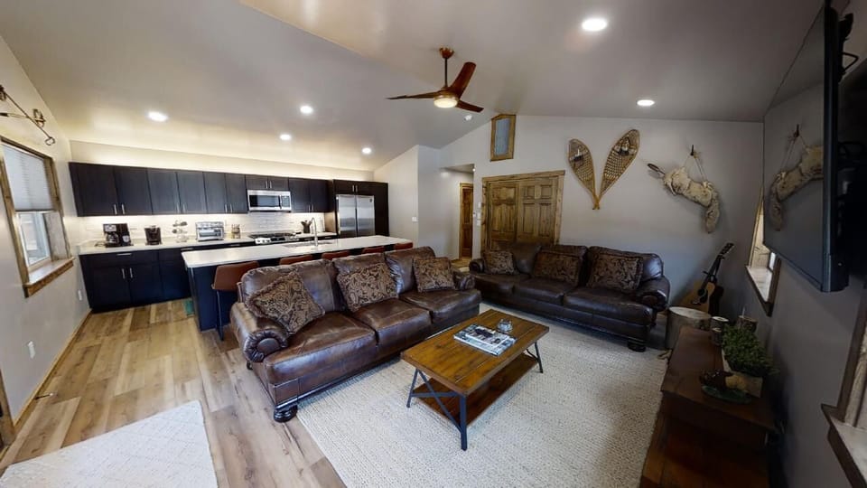 Step into your mountain retreat featuring a spacious open layout with rich leather seating, a fully-equipped kitchen, and distinctive decor that invites you to relax after your adventures.