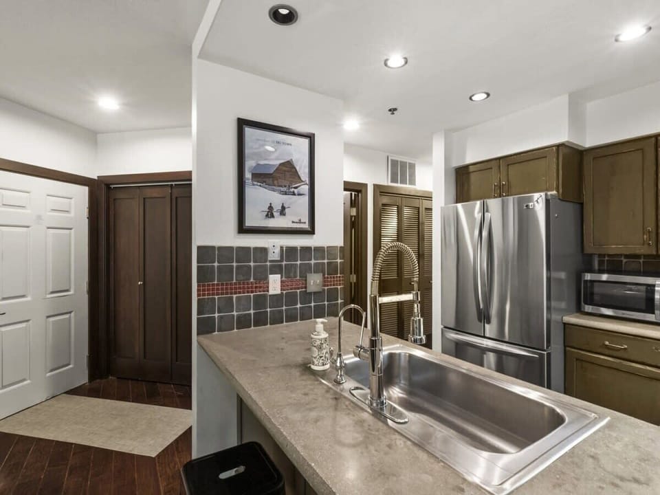 The lovely kitchen features everything you need to whip up a favorite meal from a large, single-basin sink and roomy stainless steel refrigerator and boasts a convenient bar/serving area with seats for two.