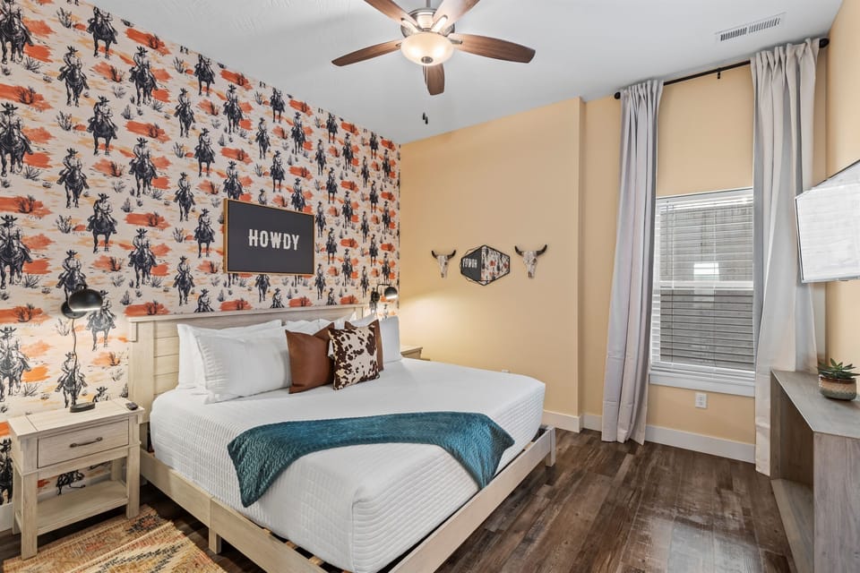 Saddle up in style! This western-themed king suite features rustic wood textures, leather accents, and warm lodge tones that bring the spirit of the Ozarks to life.