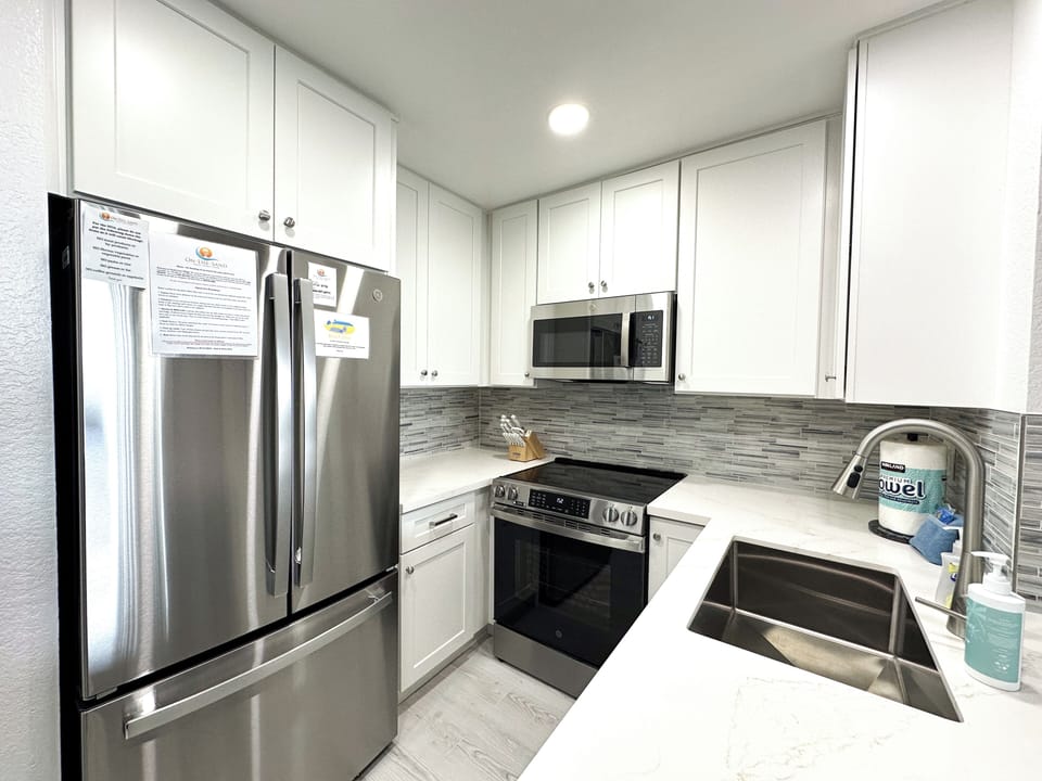 Fully stocked kitchen with all-new stainless steel appliances, including refrigerator, oven, dishwasher, and microwave (January 2026).