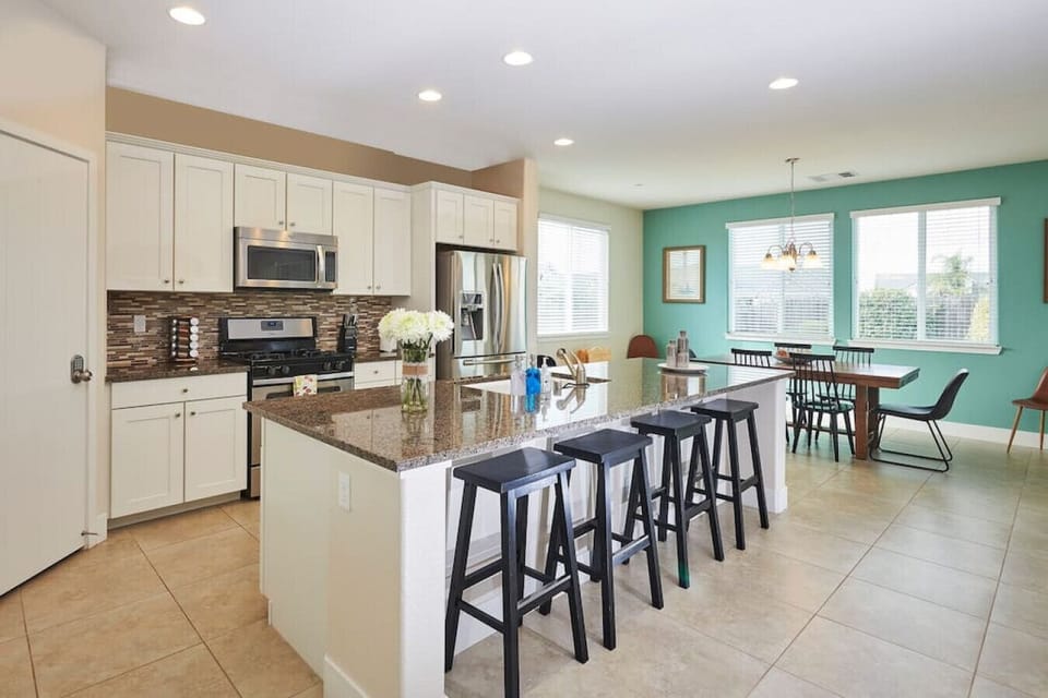 Spacious fully equipped kitchen with countertop and chairs.