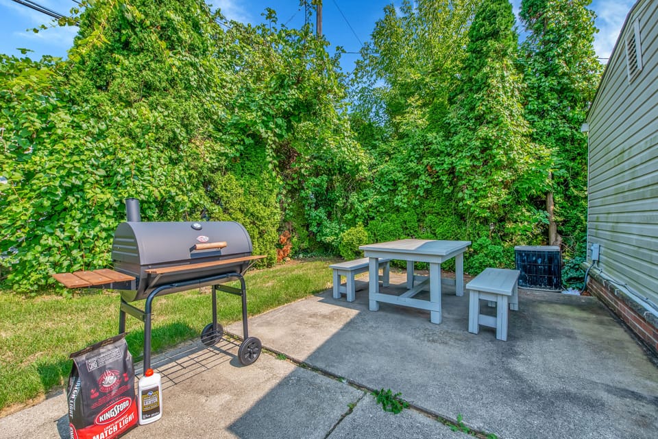 Enjoy a fenced backyard with a grill, picnic table, and lounge area.