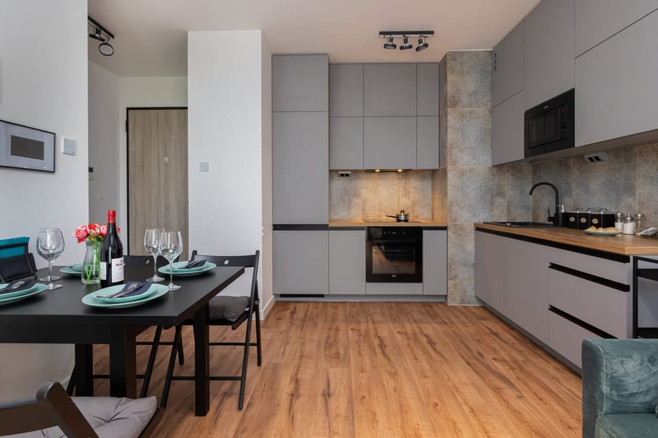 A dining area connected to a spacious kitchen, decorated with contemporary furniture and art on the walls.