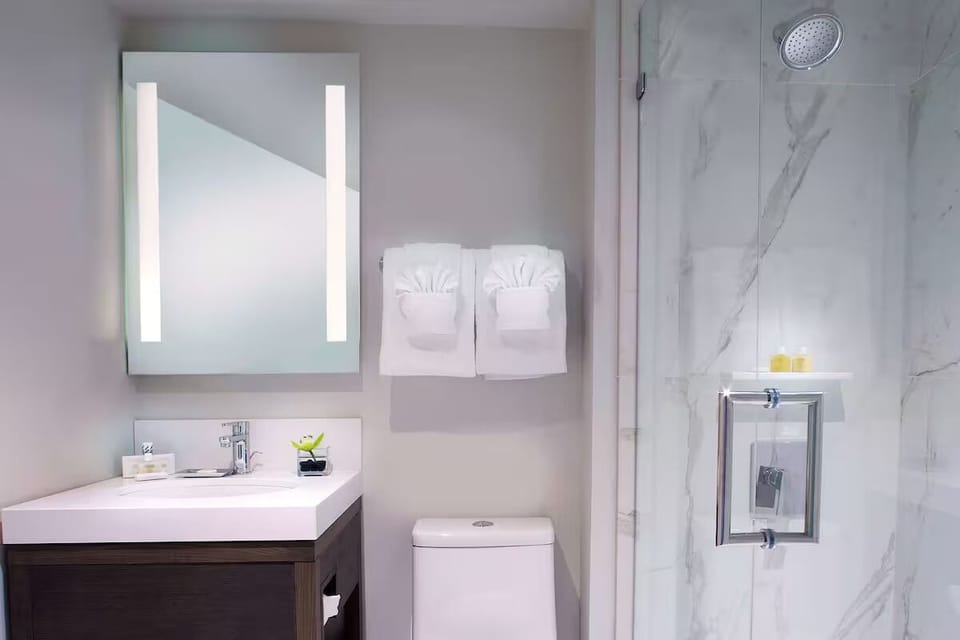 Refresh in a spotless marble bath with glass walk-in shower.