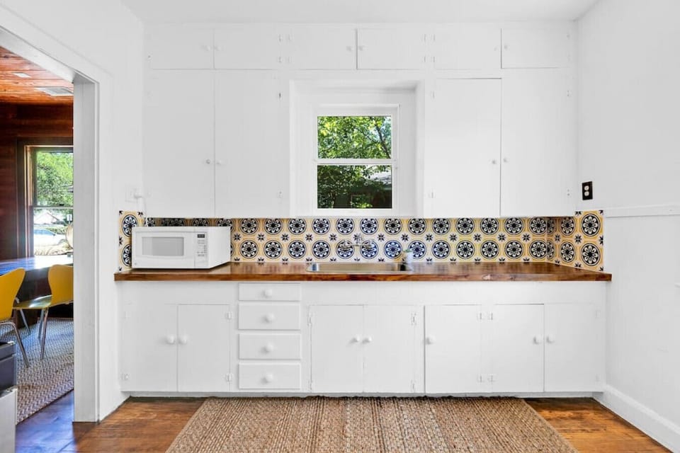 Cute kitchen with sink, fridge, stove, and microwave plus coffee maker